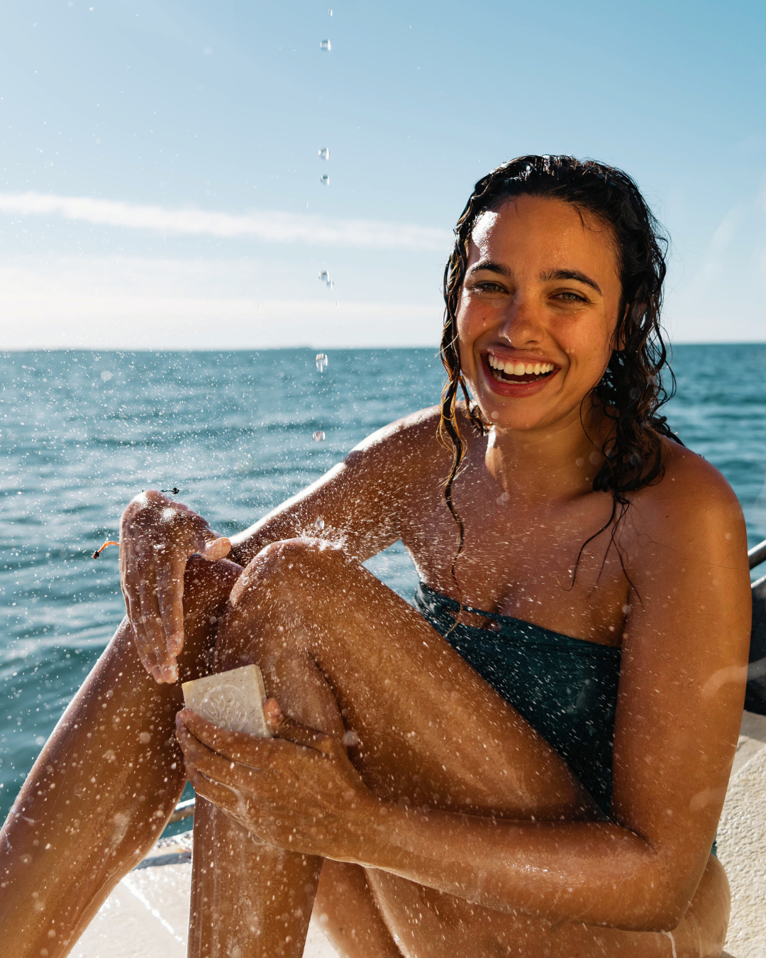 Young woman using Wash Bloc Exfoliator on a boat